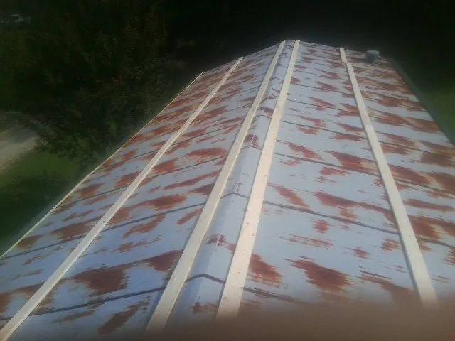 Rusted metal roof panels with new wood purlins before replacement — Storm Damage Roof Repair in Flowery Branch by Roofing Brothers