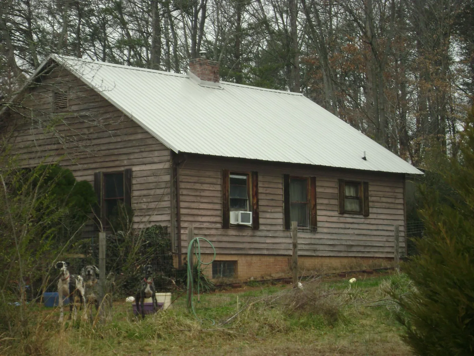 White metal roof on an old wood sided farmhouse, from a Asphalt Shingle Roof Repair job in Flowery Branch